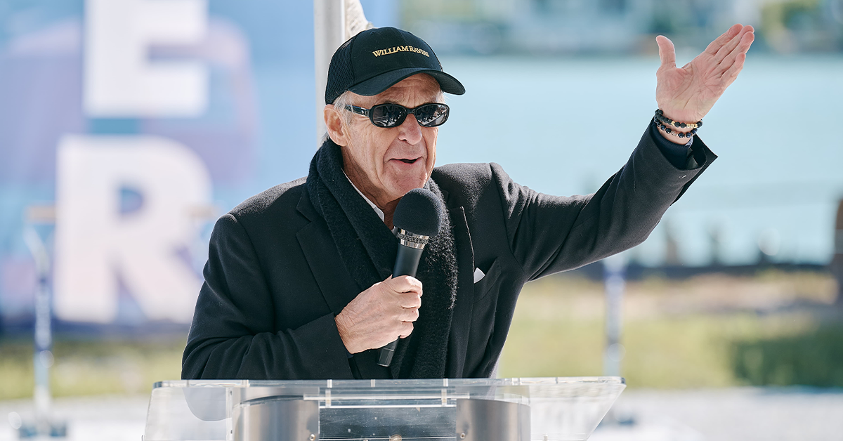 Speaker wearing sunglasses addresses attendees at the 3300 Gulf Shore groundbreaking.