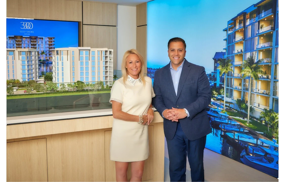 Joe and victoria professionals stand beside a model of a waterfront residential development.